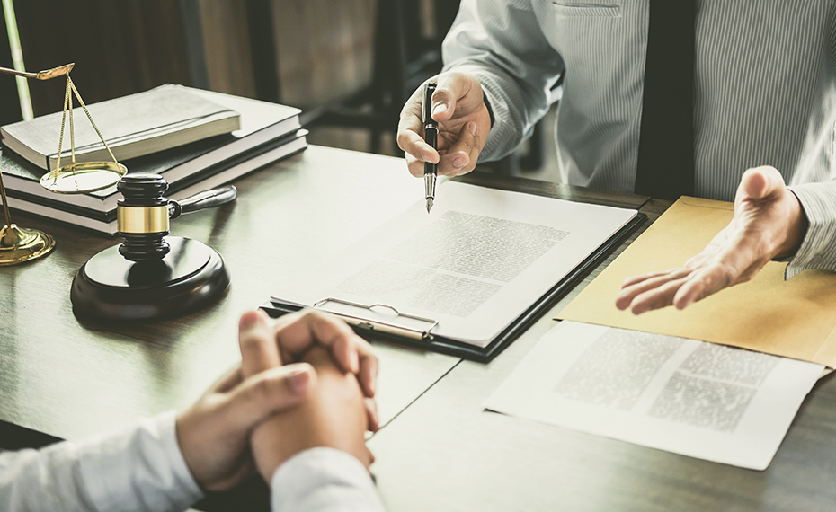 lawyer talking with client over paperwork